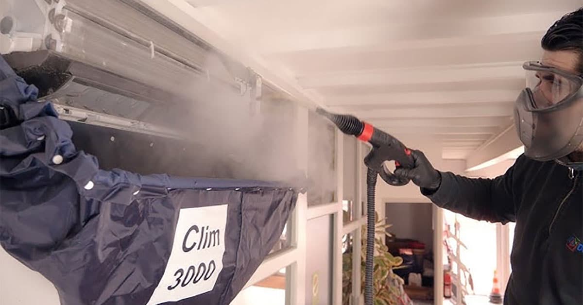 Concept Clim décontamination de climatisation. Photo d'un homme nettoyant à la vapeur une climatisation avec Clim3000